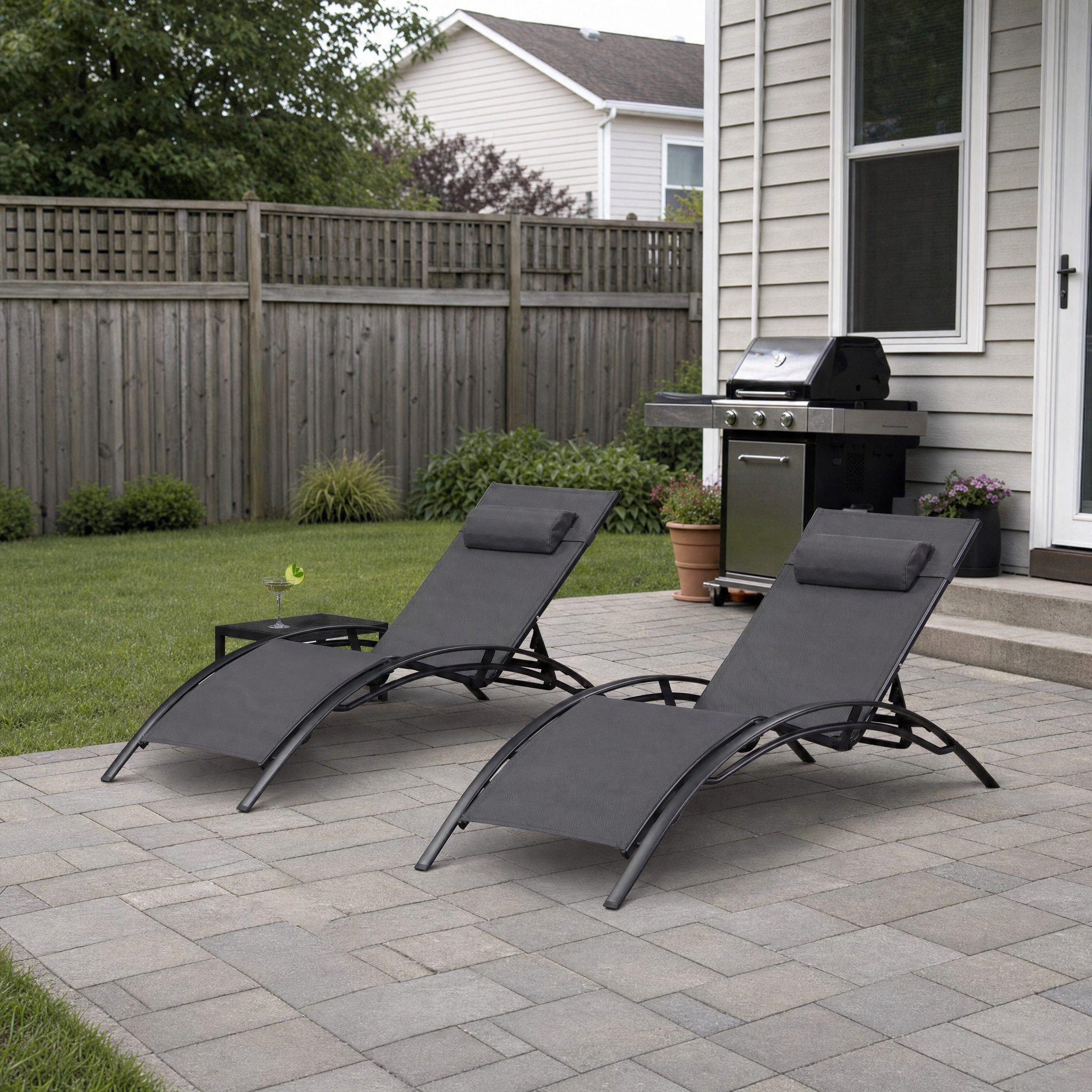 Black-frame grey-mesh chaise lounger set with black side table on patio