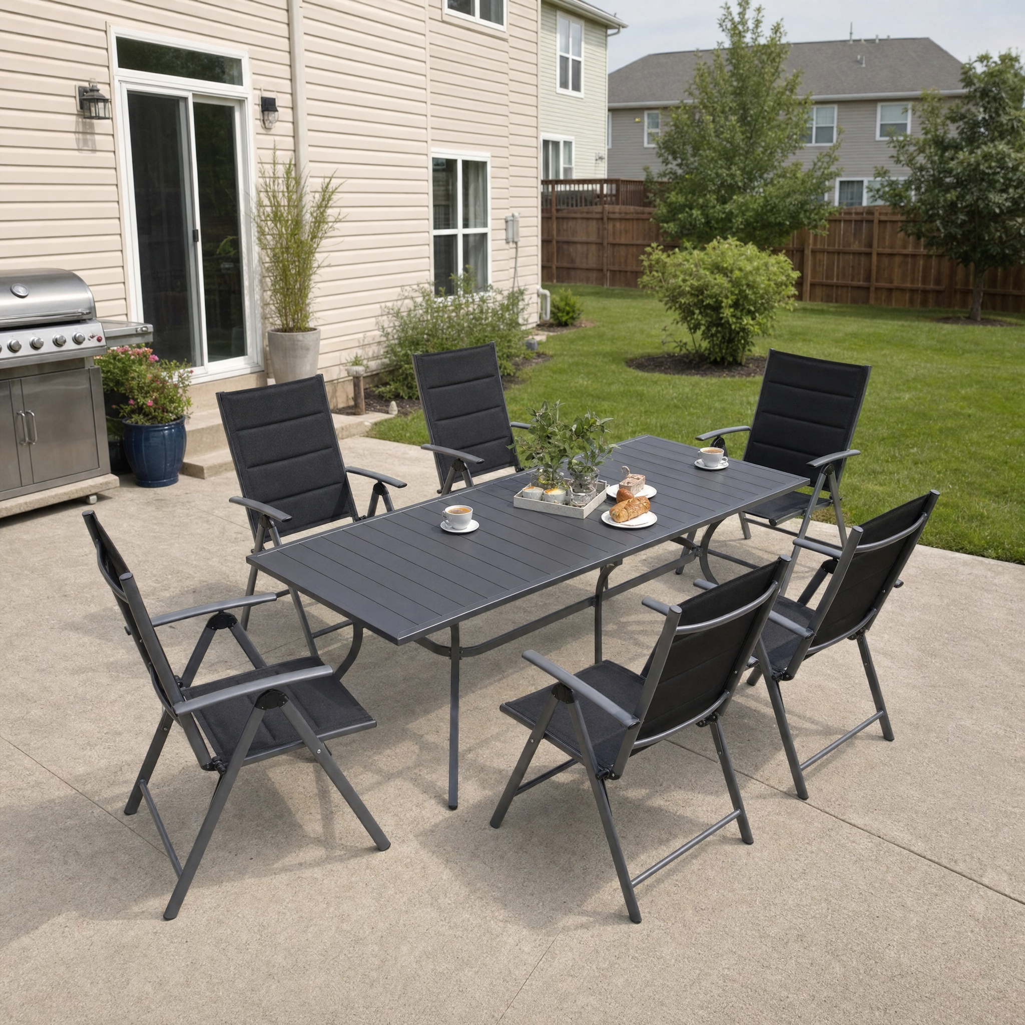 Folding dining set with grey slat table and six black padded recliner chairs