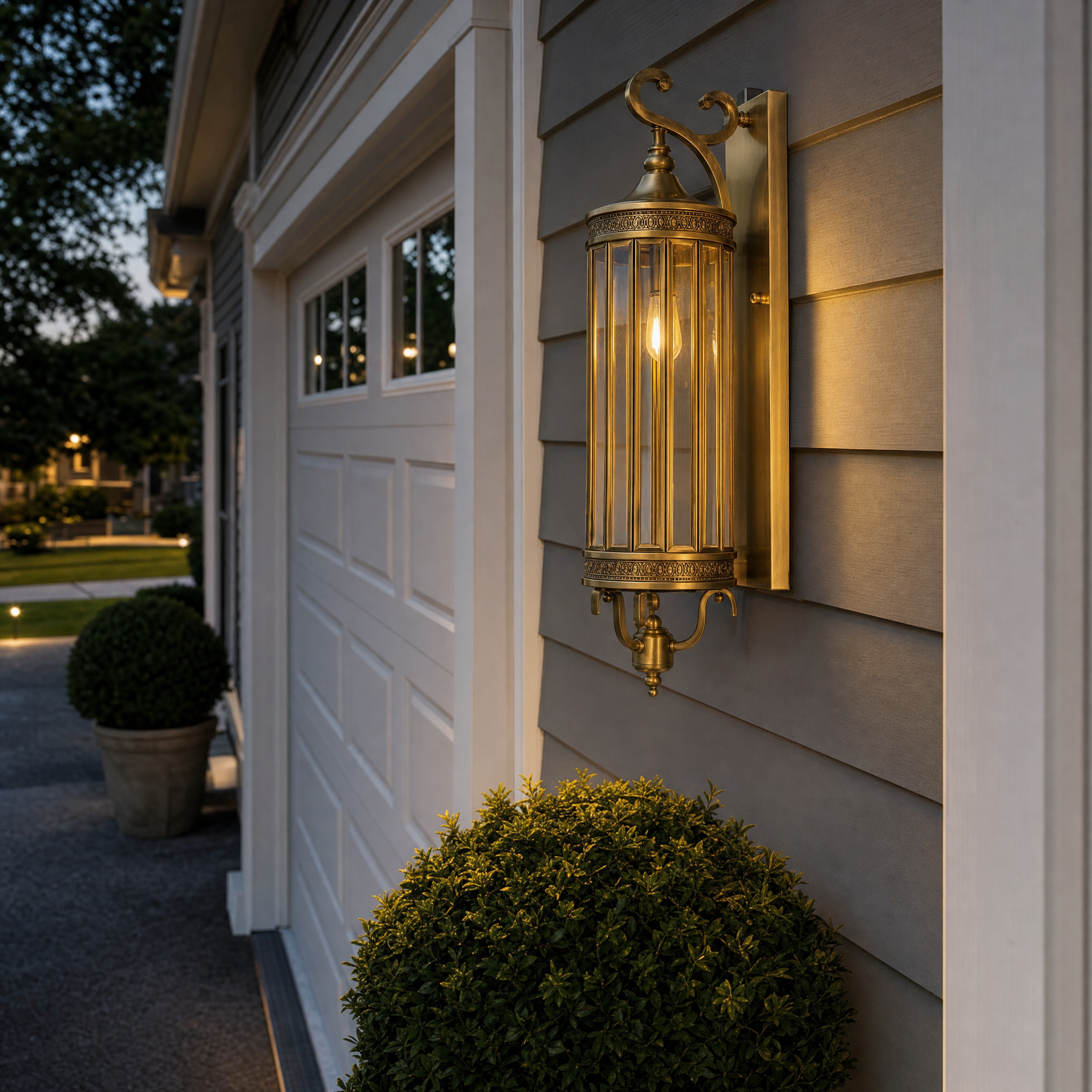 Brass cage wall lantern on home siding near garage at dusk