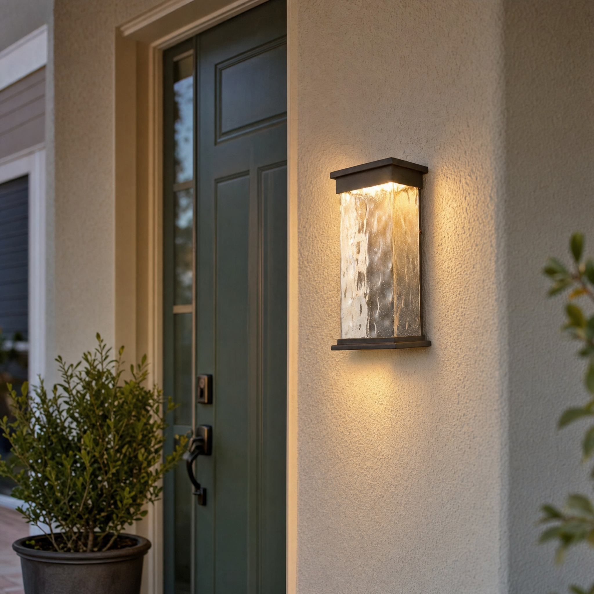 Bronze water-glass up and down wall light beside green front door